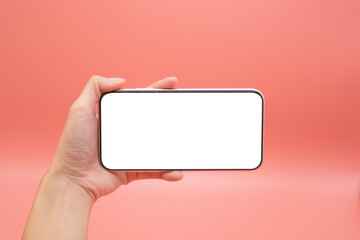 Hand woman holding mobile smartphone with blank screen isolated on pink background, close-up hand...