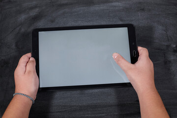 kid holding a tablet on wooden table. e-learning school. - 402801579