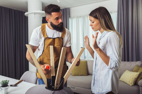 Wife helping husband to repair broken chair at home - Powered by Adobe