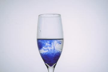 Ink in a glass of water in white background 