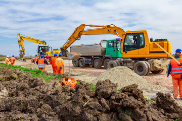 Group of workers with safety vests and helmets at construction site