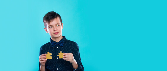Boy holding gold color puzzle jigsaw. World autism awareness day concept
