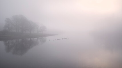 Stunning landscape image of misty Derwentwater in Lake District on cold Winter morning