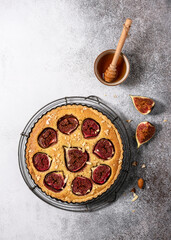 Top view of homemade delicious tart with fresh figs, almond nuts and honey. Copy space.