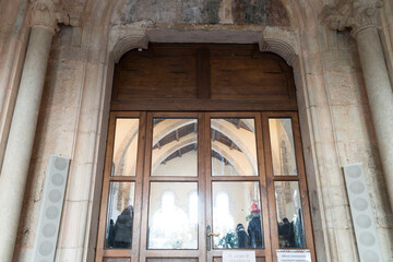 Riflessi di luce su una porta anticacon colonnine di pietra e archi in interno