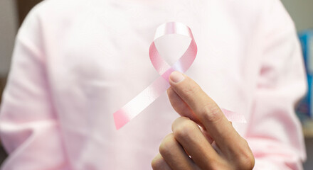Hand with pink ribbon, World cancer day concept background