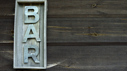 a sign that reads bar in a wooden frame on an old wooden pallet wall