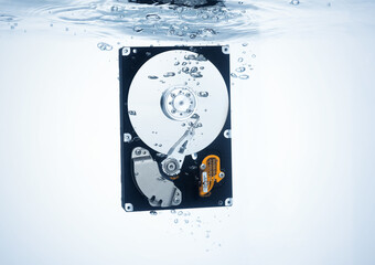 Open computer hard drive dropped into water, sinking stored data concept