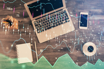 Double exposure of forex chart drawing over table background with computer. Concept of financial...