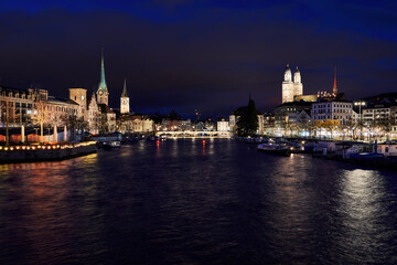 Fototapeta na wymiar Zürich Altstadt bei Nacht, Blick von Quaibrücke Richtung Münsterbrücke und die Kirchen Fraumünster, St. Peter und Grossmünster