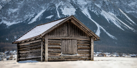 very old log barn made of wood with snow on the roof in winter in Tiroler Zugspitz Arena