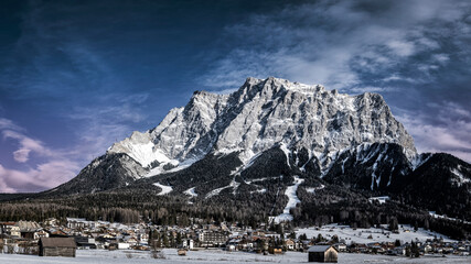majestic zugspitz wetterstein mountains and the village of ehrwald in tyrol in winter with colorful...