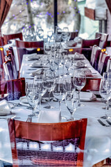 Interior of restaurant with tableware and utensils on tables with white cloth