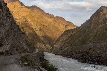 Fototapeta na wymiar River Panj (Pyandzh) between Tajikistan and Afghanistan. Pamir Highway road carved in the left.