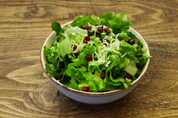 green salad, cheese and pomegranate on wooden table. healthy diet. - 402814140