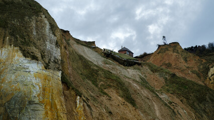 house collapsing from a cliff on the seashore, normandie