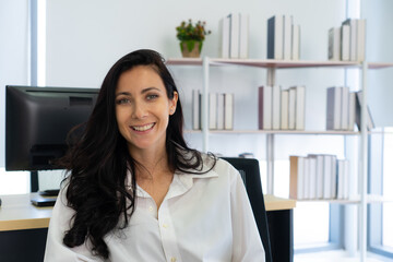 young caucasian businesswoman with smiling face sitting in working office