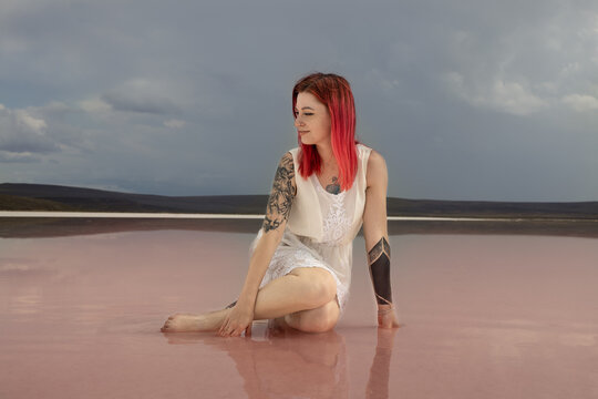 red haired pretty girl on pink salt lake, crimea