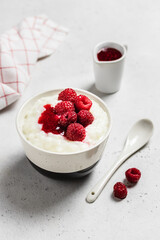 Vanilla creamy rice pudding with fresh  berries and  jam  in a bowl. Space for text.