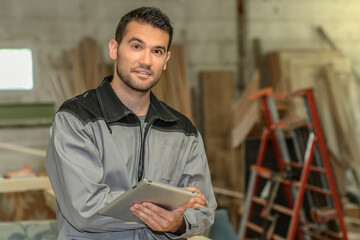 Carpenter checks the plans of the project on his tablet