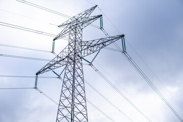 Photo of a high voltage tower in the middle of nature. Photo from the bottom. Electricity, power, light.