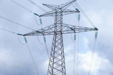 Photo of a high voltage tower in the middle of nature. Photo from the bottom. Electricity, power, light.