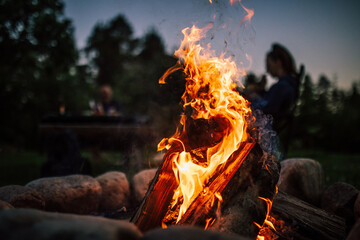 Bonfire in a camp with people in the background