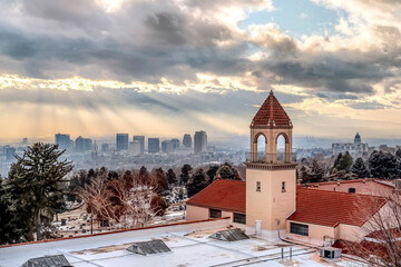 Snowy rooftop with bell tower of a church with Salt Lake City view in the background