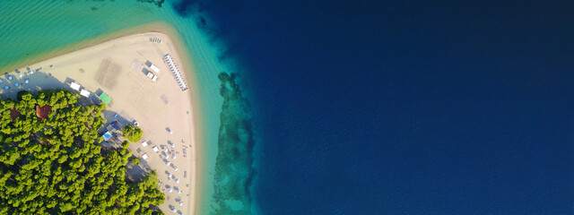 Aerial drone ultra wide panoramic photo of turquoise exotic island bay with calm sea and organised sandy beach