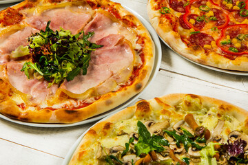 Different slices of pizza with different toppings on a white background. Cut into slices delicious fresh pizza. Tasty pizza on white.