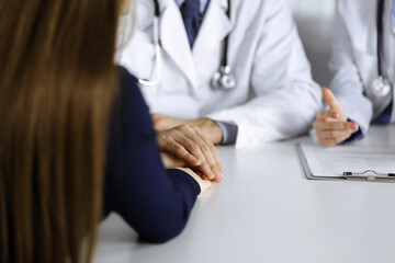 Unknown man-doctor reassuring his female patient, close-up. Two physicians consulting and giving...