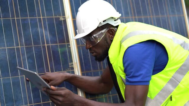 African american technician using laptop computer checking Solar Cell panels . engineer repair and maintenance photovoltaic