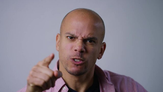 Portrait of angry man pointing to camera and expressing his anger, in slow motion