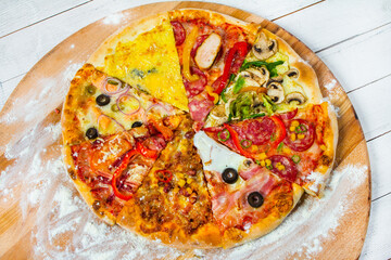 Different slices of pizza with different toppings on a white background. Cut into slices delicious fresh pizza. Tasty pizza on white.