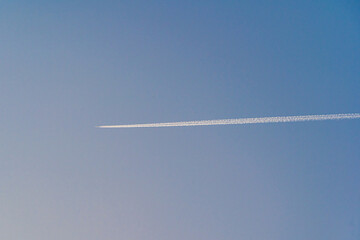 快晴の空にまっすぐ伸びる飛行機雲