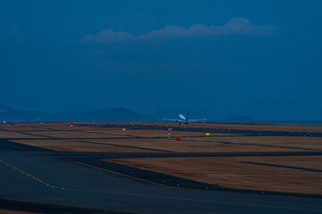 夕闇迫る中離陸する航空機