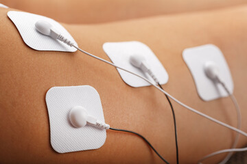 Muscle stimulator with electrodes, the massager on the buttocks and legs. - obrazy, fototapety, plakaty