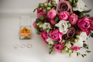 wedding gold rings with bridal bouquet on the table