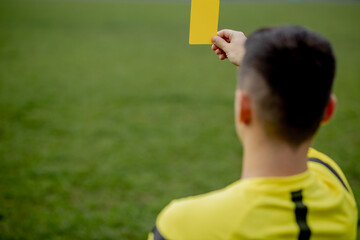 Naklejka premium Referee showing a red card to a displeased football or soccer player while gaming. Concept of sport, rules violation, controversial issues, obstacles overcoming.
