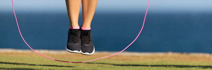 Young fitness woman warming up with jump rope outdoors - obrazy, fototapety, plakaty