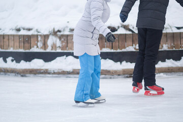 People skate in the winter in the cold on the ice rink.