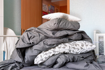 Close up image of big pile of gray bedclothes and white pillows
