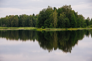 Fototapeta na wymiar Lake in forest with reflection of trees in water