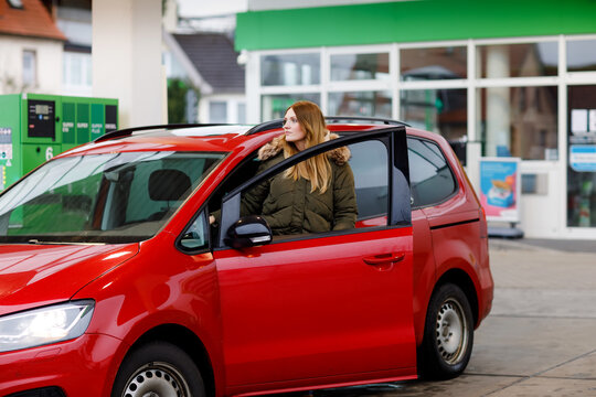 Young Attractive Woman Gets Out Of Her Car By Gas Station To Refill Car With Petrol Or Gas. People Refuel Gasoline, Driving, Transport Concept. Self Service Gas Pump