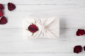 Valentines zero waste concept. Eco friendly gift with dried rose petals on the white wooden background, flat lay