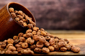 Tiger nuts falling out of a wooden cup