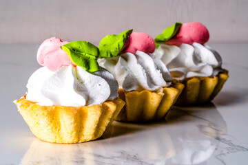 Meringue cakes in a basket on the table