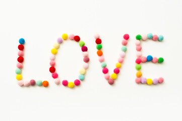 Handmade Valenine pom poms decoration. Written word "Love".