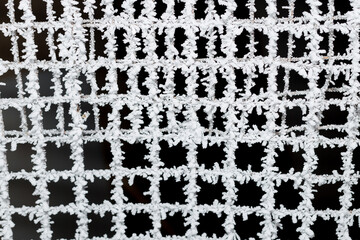 iron mesh covered with frost on a black background