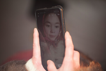 A young girl, in the national winter clothes of the northern inhabitants of the tundra, takes a selfie on a smartphone